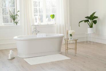 White modern bathroom with silver fittings with large sunny wind